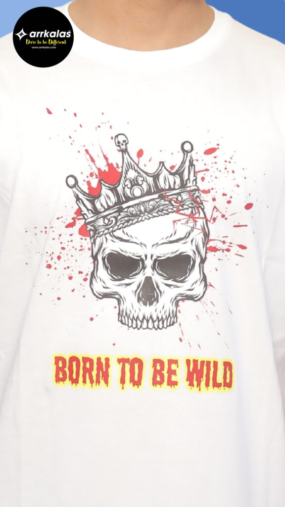 A fierce skull crowned in royalty, drenched in blood splatter, commands chaos with every stare. “BORN TO BE WILD” blazes beneath in savage red and yellow, screaming rebellion from the dark throne.