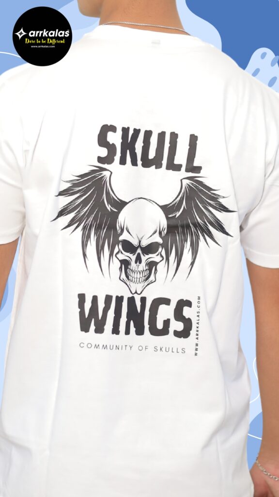 Back design of a dark-themed T-shirt featuring a fierce winged skull graphic with the bold text “SKULLWINGS – Community of Skulls,” representing the rebellious spirit of the Arrkalas brand from the dark side