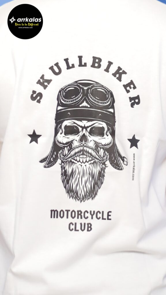 A brutal biker skull with a battle-worn helmet and fierce beard leads the outlaw ride. This “Skullbiker Motorcycle Club” tee by Arrkalas roars with raw power and road-born rebellion