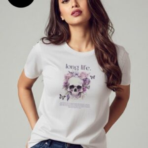 A woman’s white T-shirt features a striking design with the phrase “long life.” above a watercolor skull surrounded by soft pastel flowers and delicate butterflies, blending edgy symbolism with feminine elegance to express strength, resilience, and the celebration of everlasting beauty