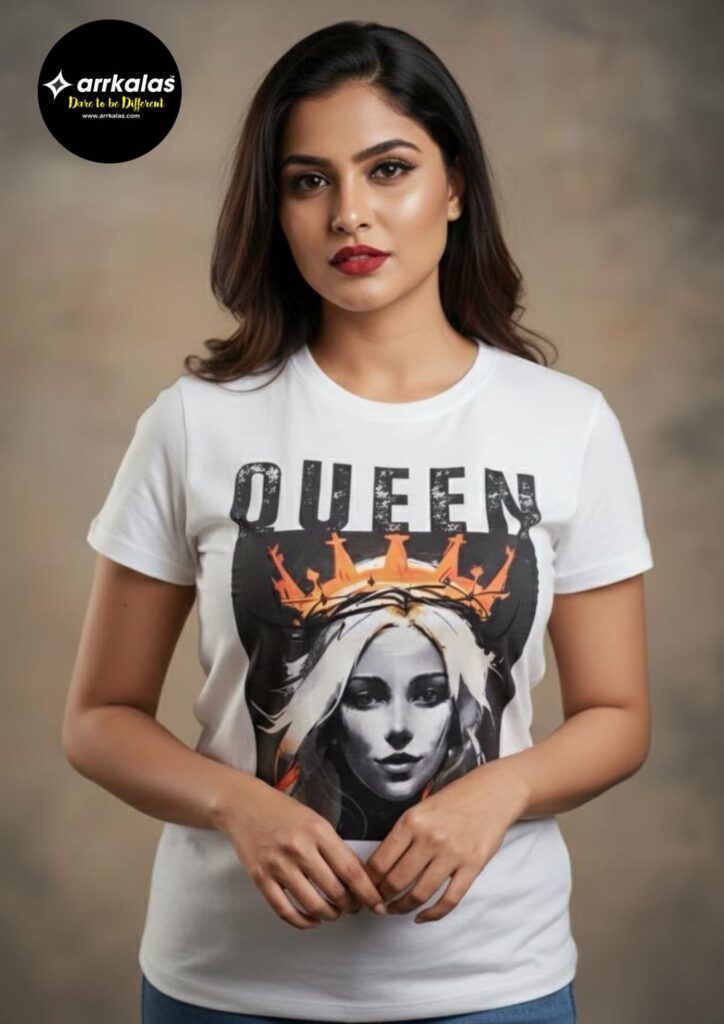Woman wearing a white T-shirt with bold “QUEEN” lettering above a vibrant graphic of a crowned figure, blending grunge and regal aesthetics