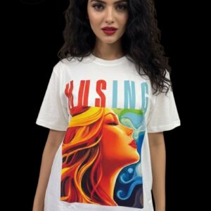 White T-shirt displayed on a mannequin, featuring an artistic graphic print and the word “MUSING” in bold, gradient colors above the artwork. The brand Arrkalas is known for creative, soulful designs