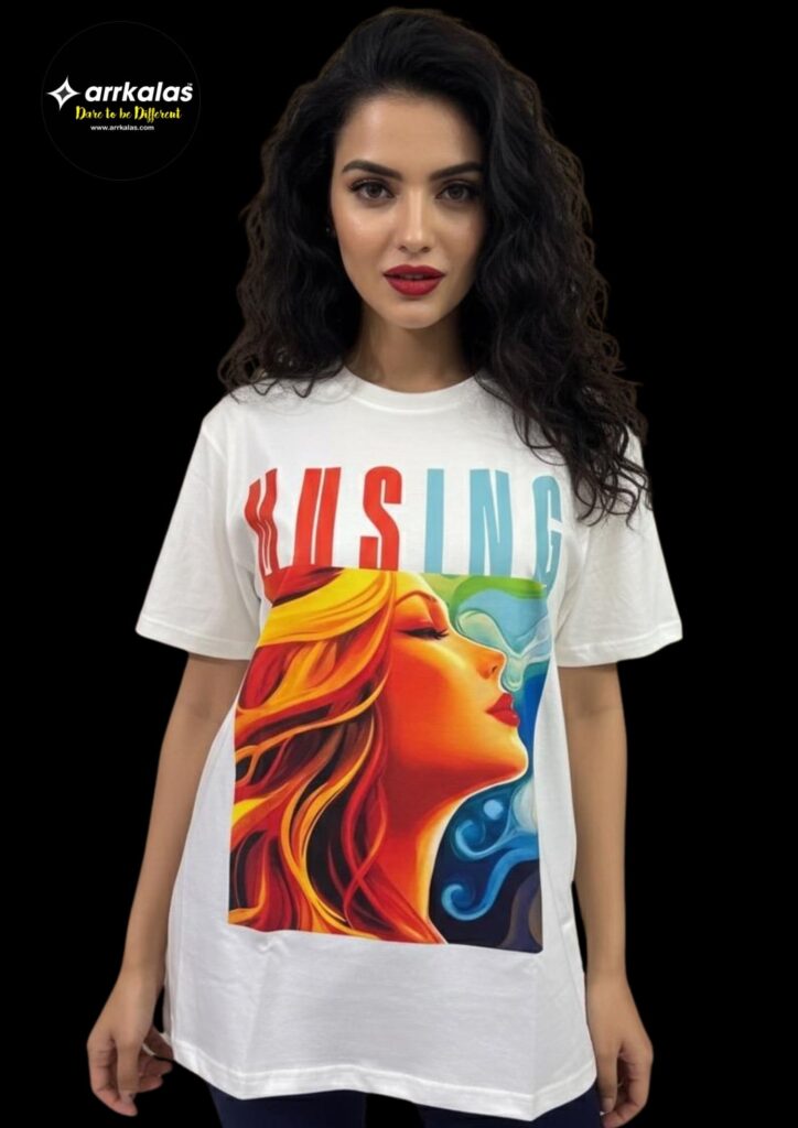 White T-shirt displayed on a mannequin, featuring an artistic graphic print and the word “MUSING” in bold, gradient colors above the artwork. The brand Arrkalas is known for creative, soulful designs