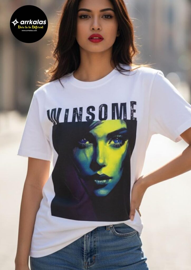 A woman in a white T-shirt stands facing away, showing the back design which features the bold word “WINSOME” above a stylish rectangular graphic in muted tones, set against a neutral concrete background