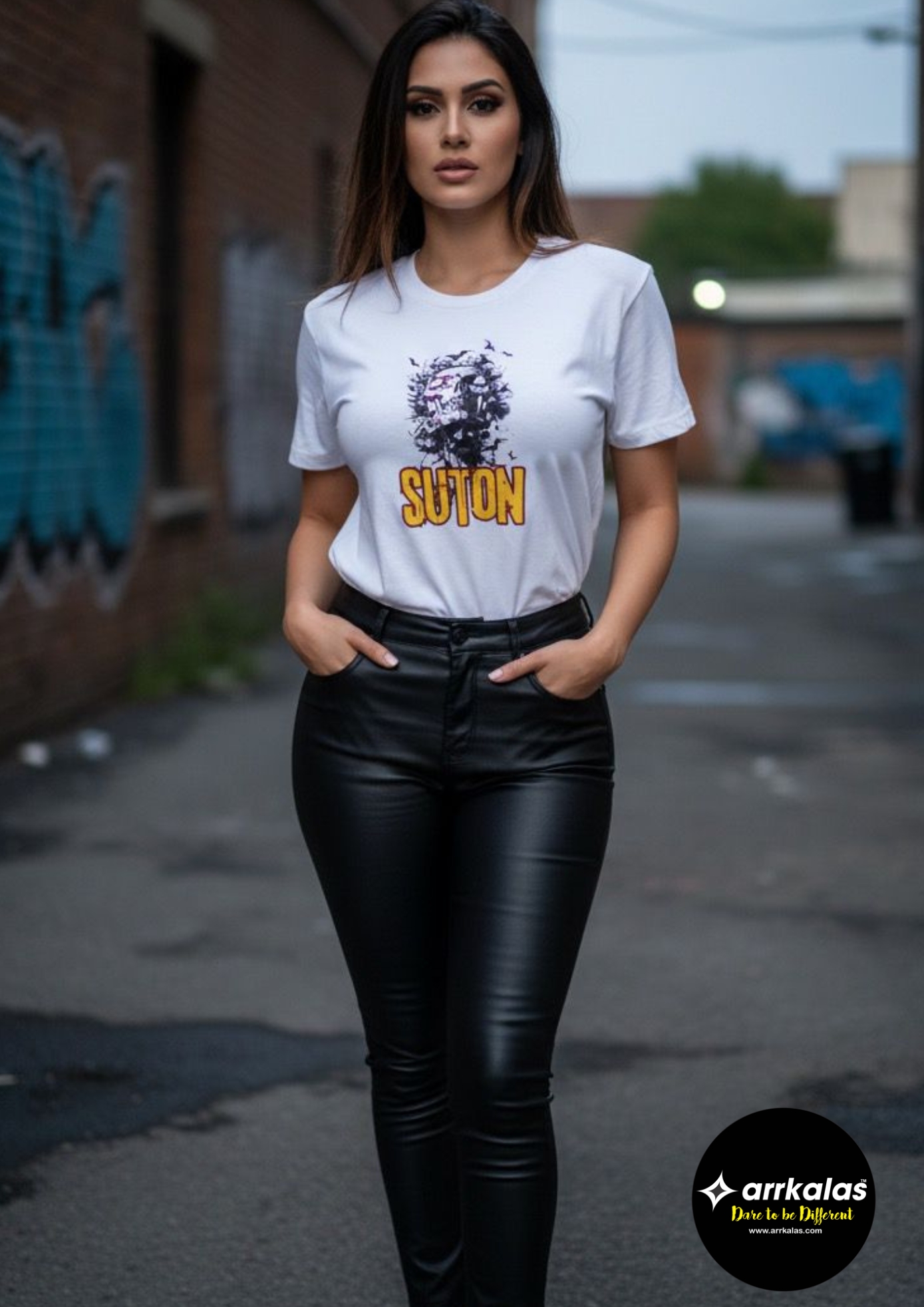 A stylish woman stands confidently in an urban setting, wearing a white T-shirt featuring a striking graphic of a detailed face surrounded by bold dark brushstrokes, with the creative word “SUTON” in vibrant yellow below, symbolizing individuality and expressive spirit