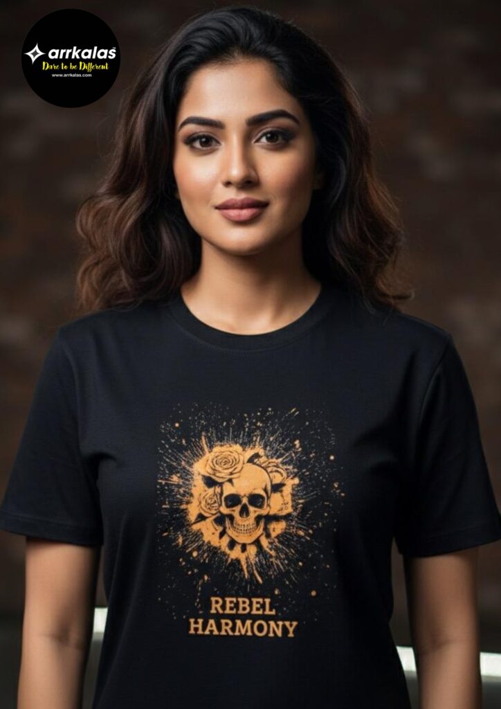 A confident woman stands against a blurred, artistic backdrop wearing a striking black T-shirt. The shirt features an eye-catching orange graphic with detailed roses and a skull at its heart, enveloped in a radiant splatter design. Beneath this powerful imagery, the words “REBEL HARMONY” are boldly printed, symbolizing both strength and grace